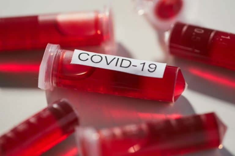 Close-up of capsules with red liquid from disease covid-19 on the table